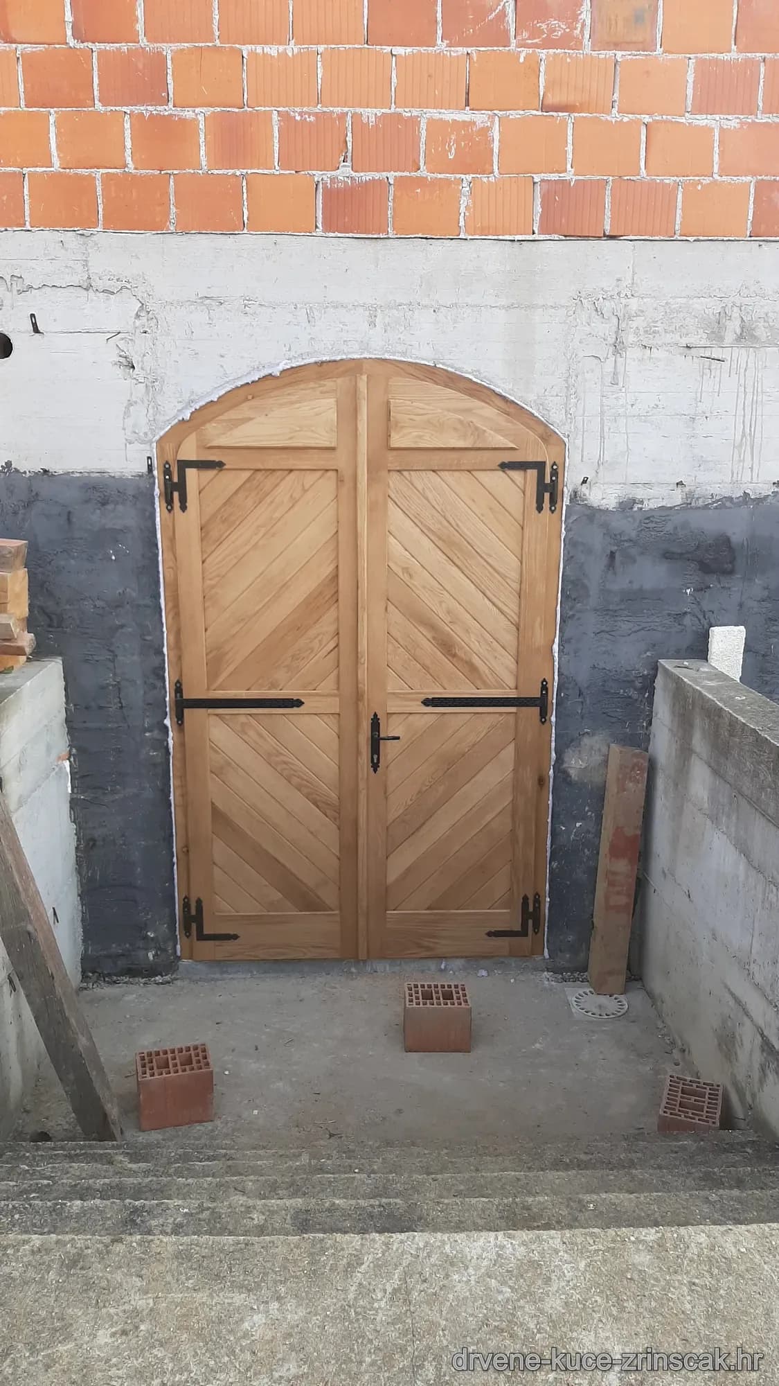 Dvokrilna lučna drvena vrata ugrađena u podrumskom otvoru