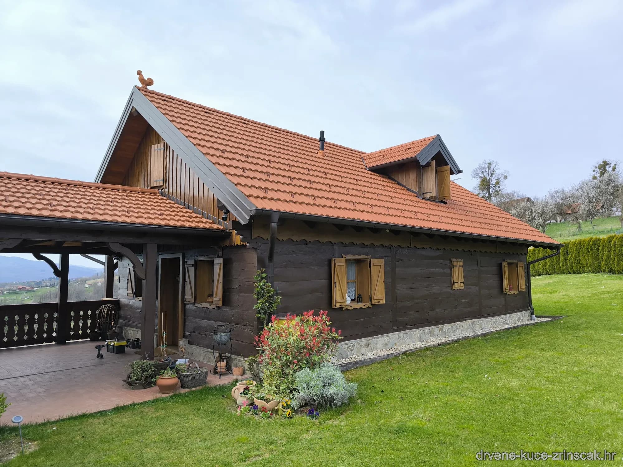 Drvena kuća – bočni pogled na objekt s uređenom okućnicom